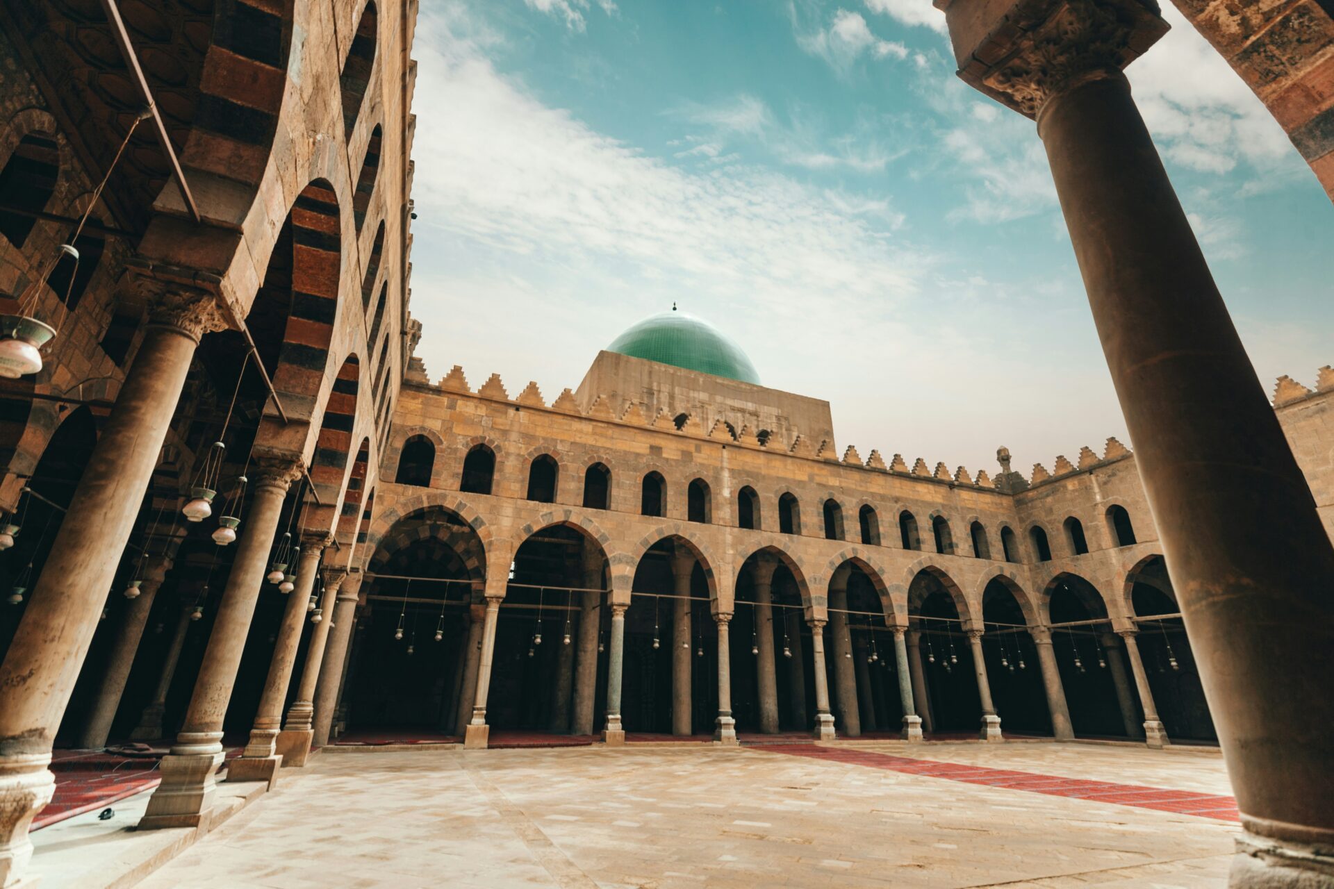 Upward angle photo of a mosque with a green dome