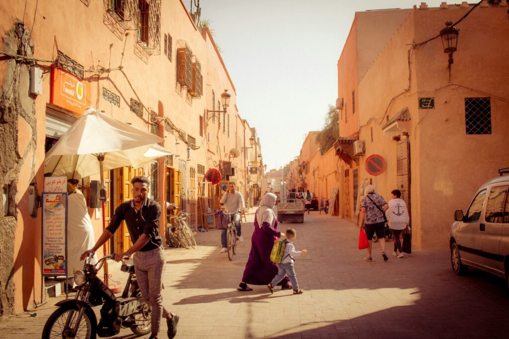 A group of people walking and biking in the street in the Middle East