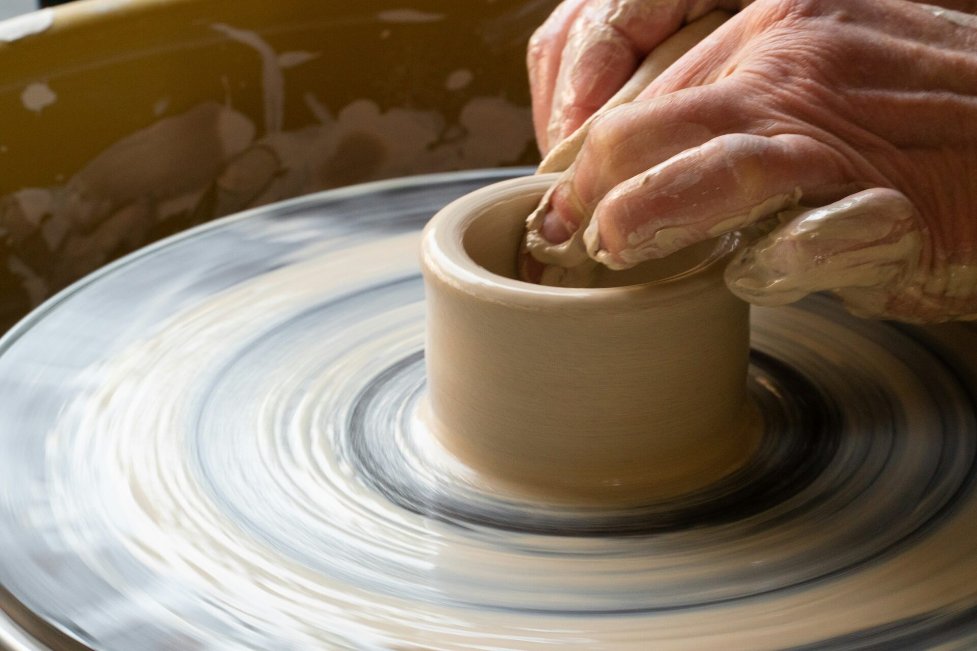 Potter shaping a bowl on a pottery wheel