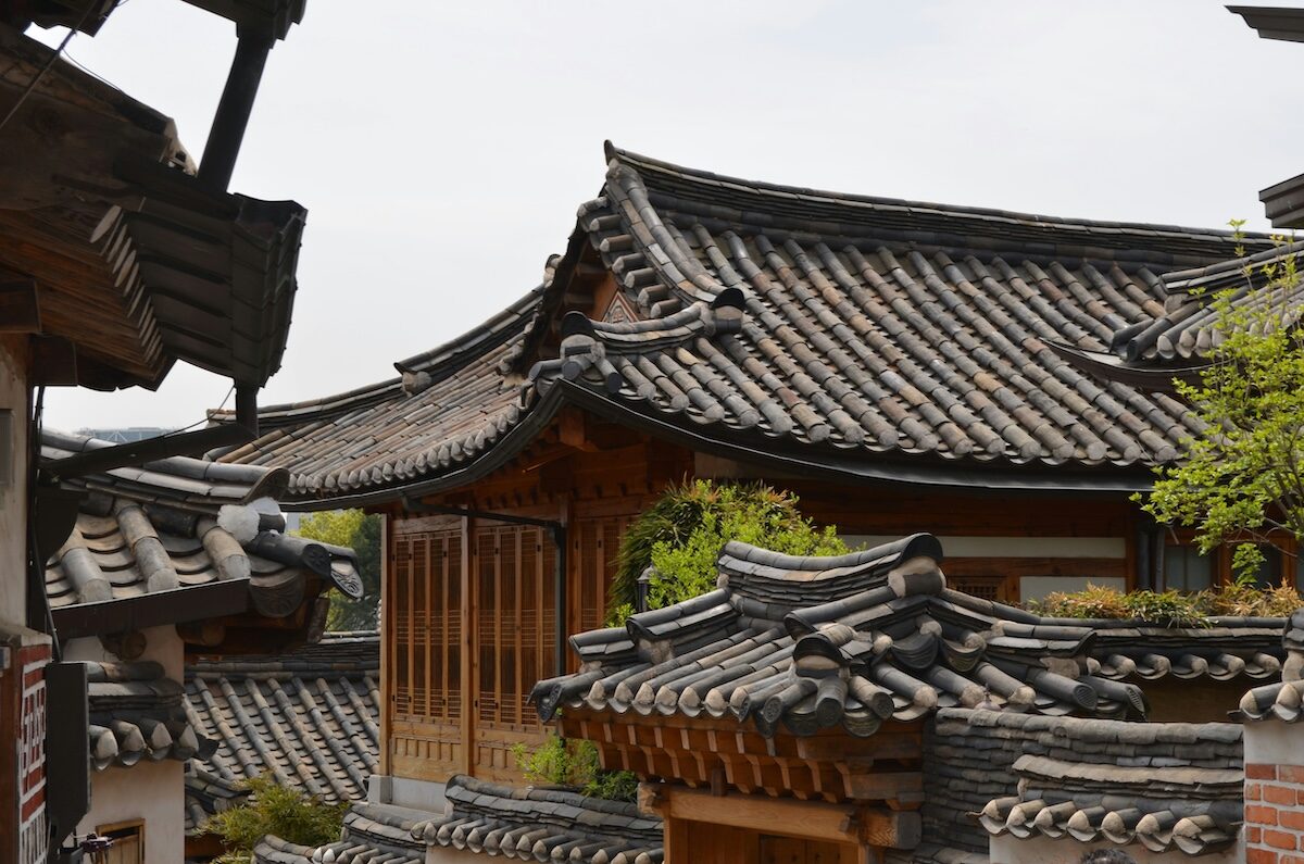 Traditional Korean hanok houses with curved tiled roofs and wooden structures clustered closely together.