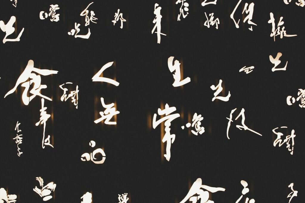 White Chinese calligraphy characters on a black background, arranged in a scattered pattern.