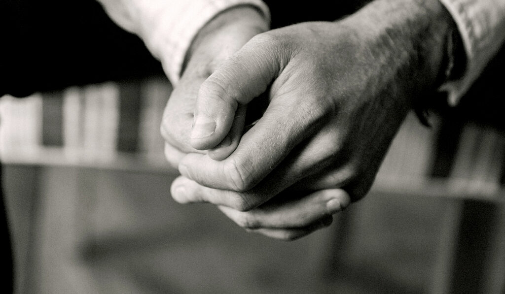 A black and white picture of folded hands.