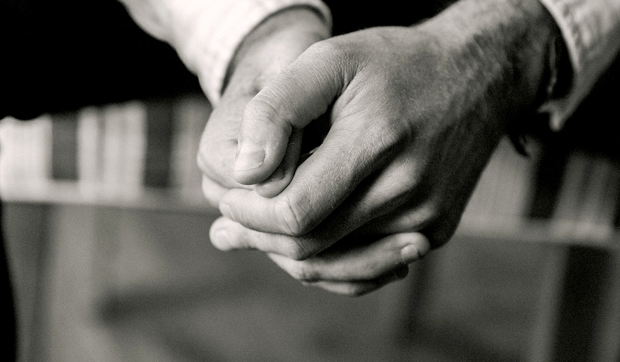A black and white picture of folded hands.