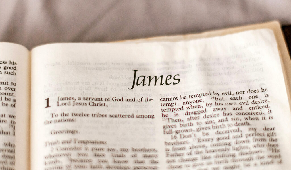 A Bible is open to the first chapter of the Book of James.