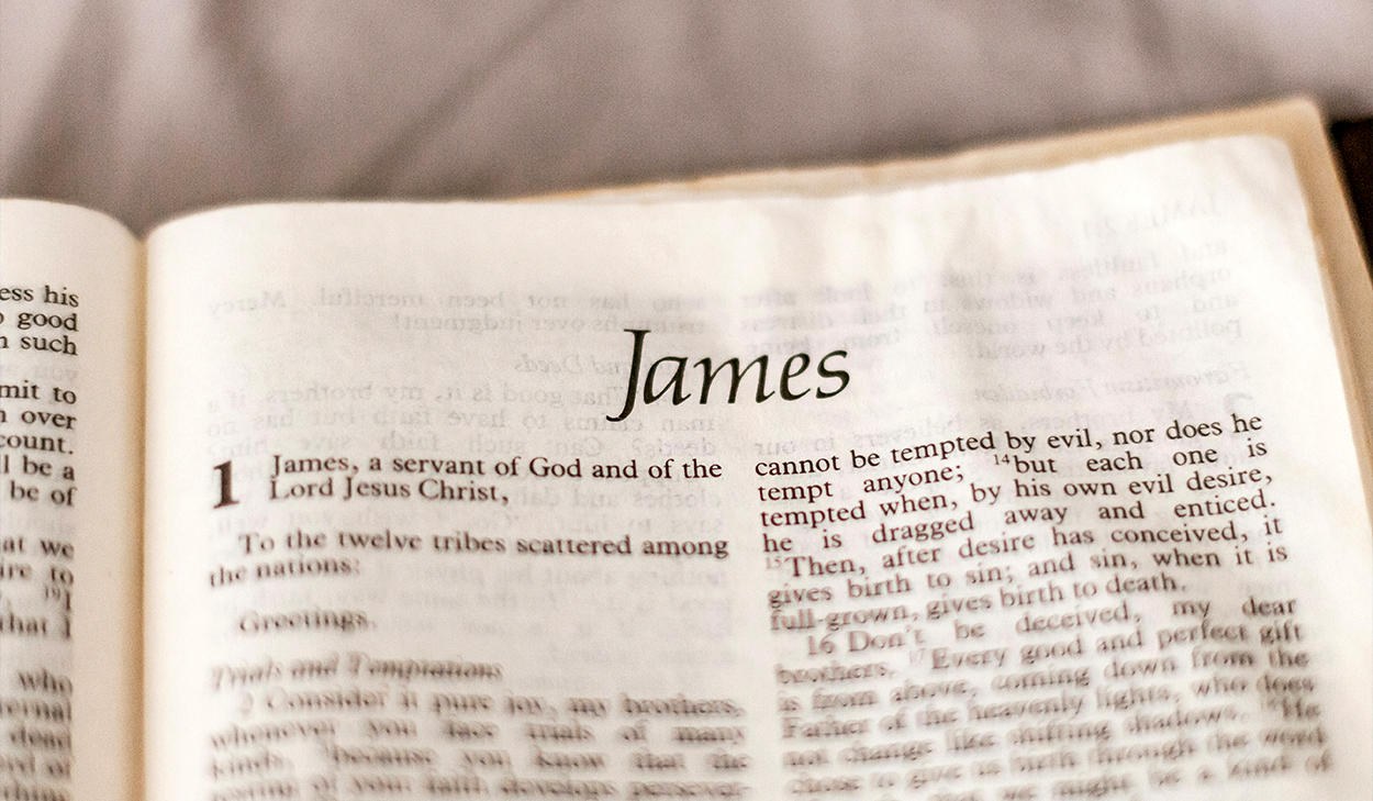 A Bible is open to the first chapter of the Book of James.