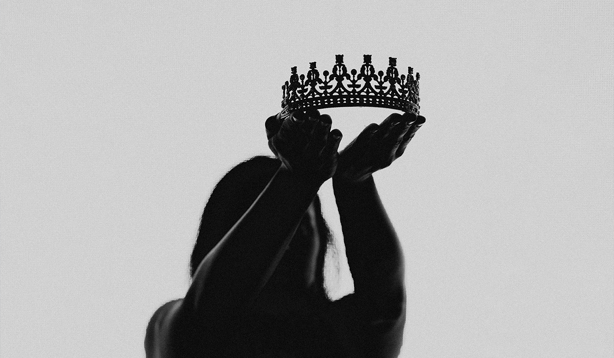 A woman holds up a crown.
