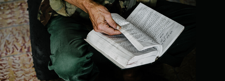 Close up of a person's hand turning the pages of an open book.