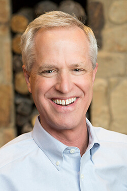 Photo of Kurt Nelson, a middle-aged white man, smiling and wearing a light blue button down.