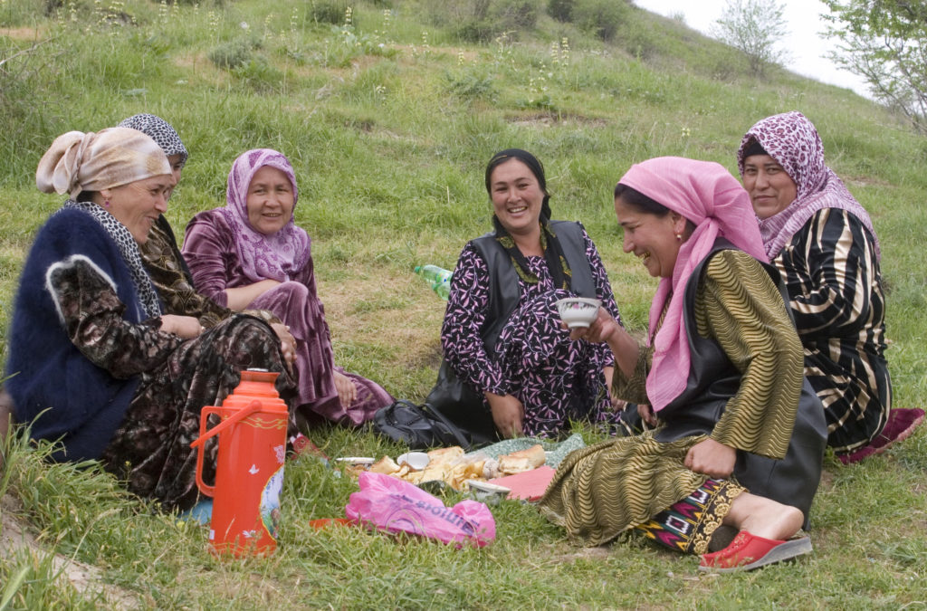 Women in central asia drink tea on the side of a hill