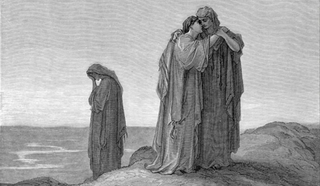 Three robed figures stand on rocky ground by the sea; two embrace in the foreground while one stands alone in the background, head bowed.