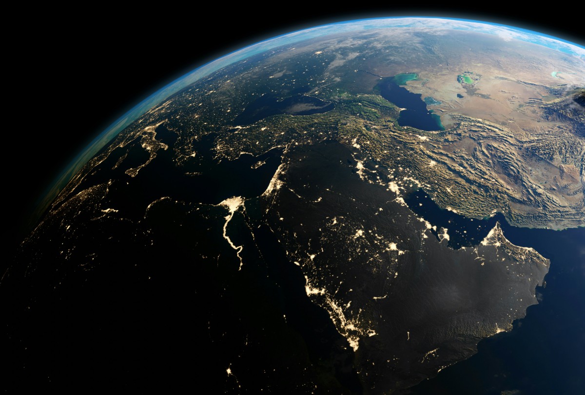 View of Earth from space showing the Middle East and surrounding regions, with visible land and water areas, under a shadowy horizon.