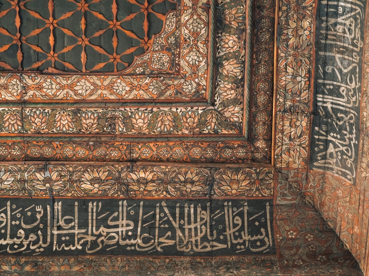Ornate architectural detail featuring intricate floral patterns and Arabic script in a geometric design.