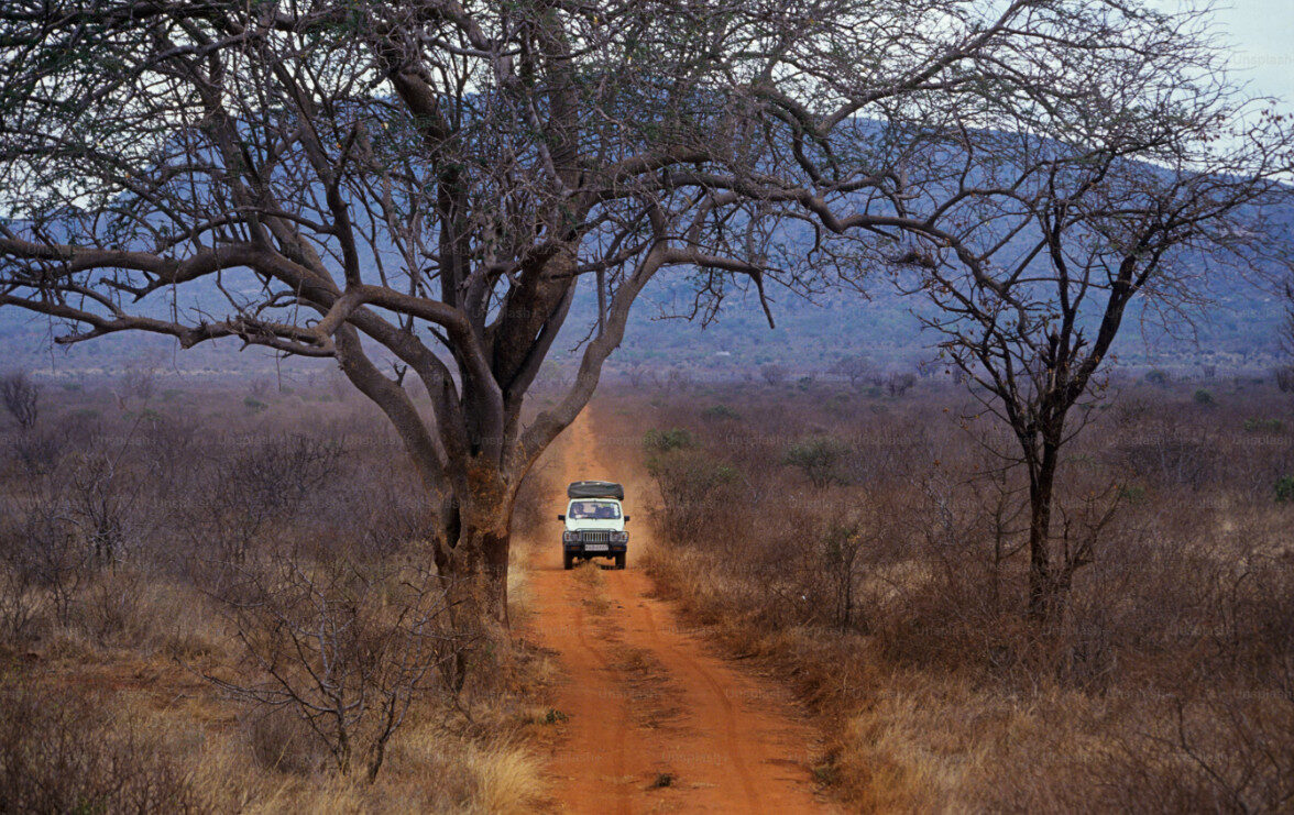 A white truck driving down a dirt road.