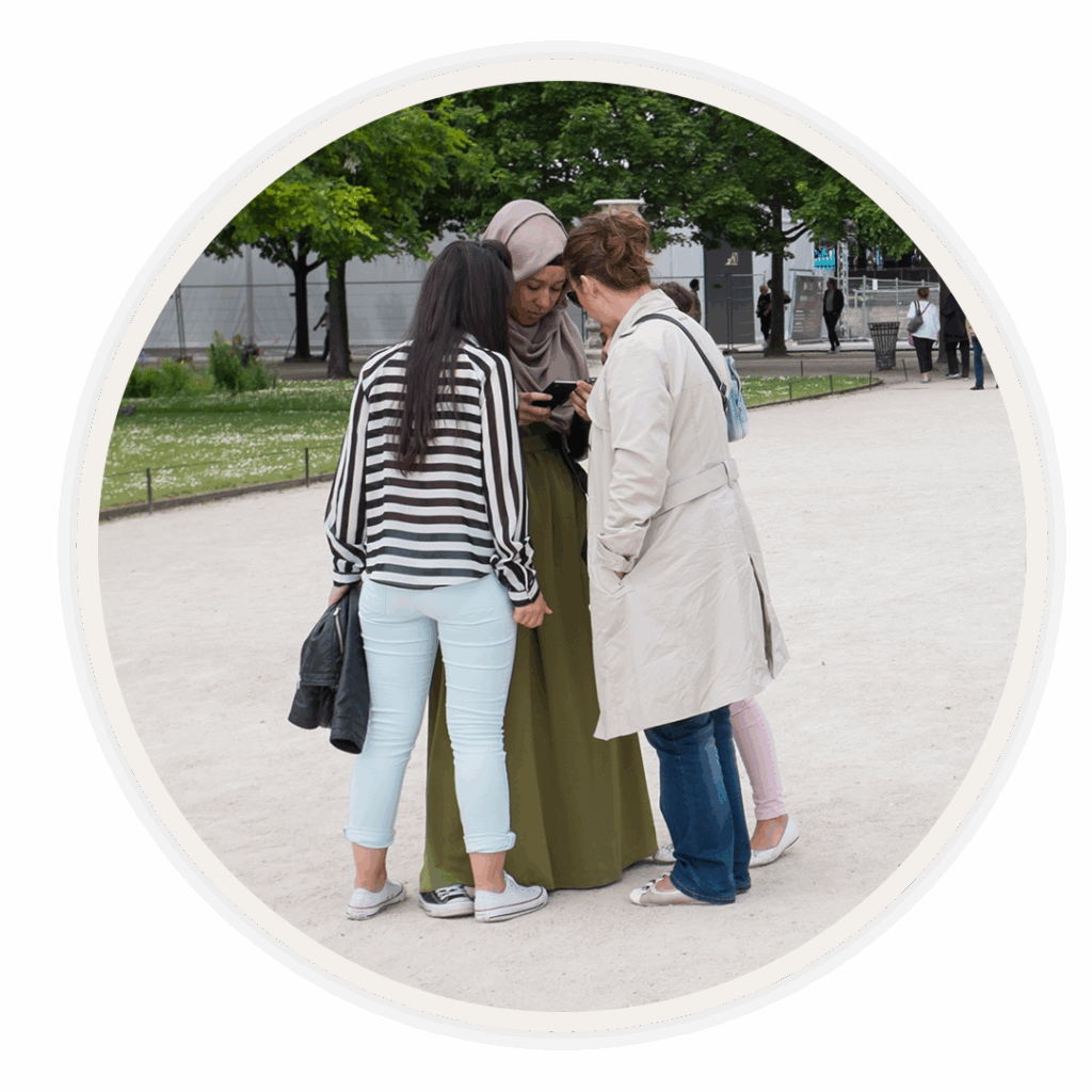 A group of people gathered in a court yard looking at a Bible.