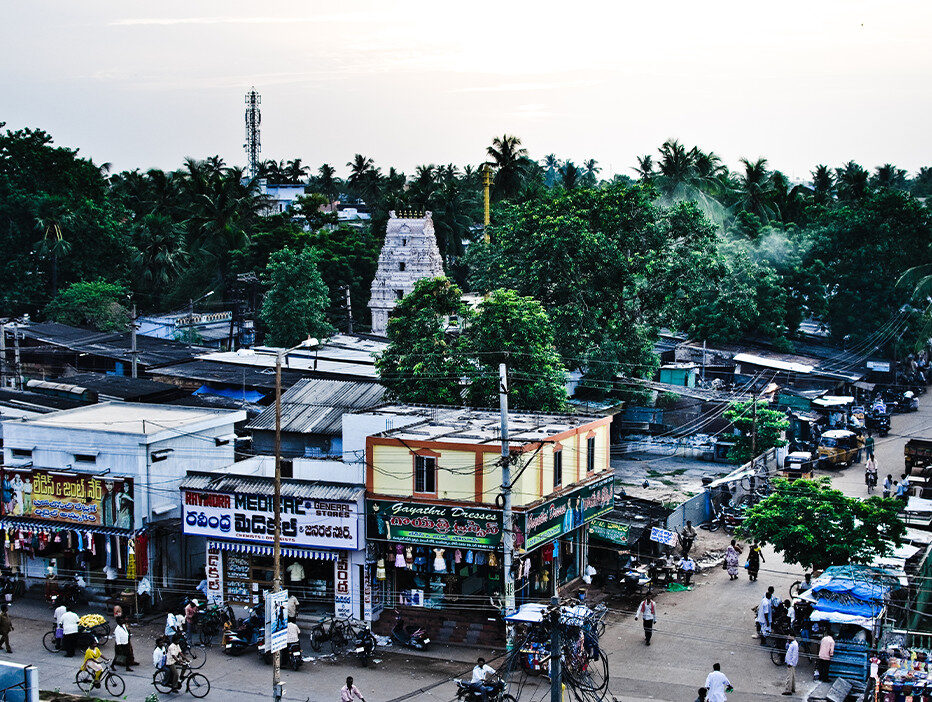 A town with buildings and people on bikes in South Asia.