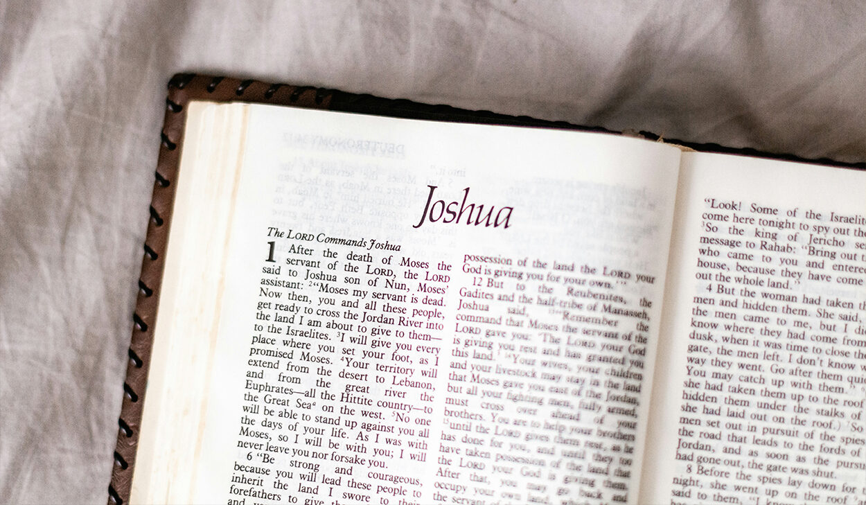 A Bible is opened to the book of Joshua.
