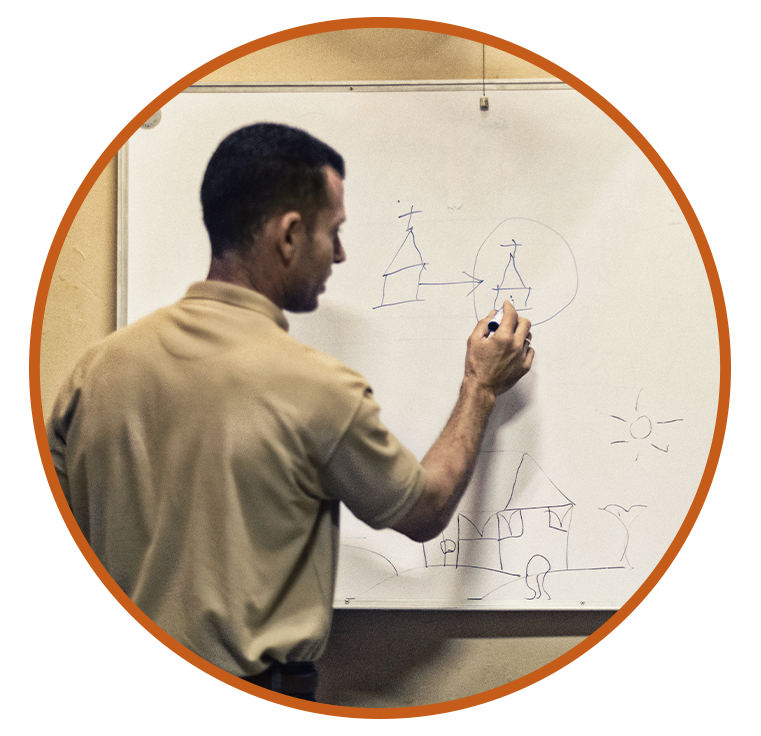 A man teaching people how to share the gospel by using a white board