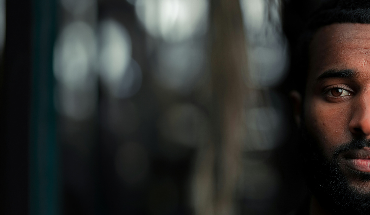 A man's face against a blurry background.